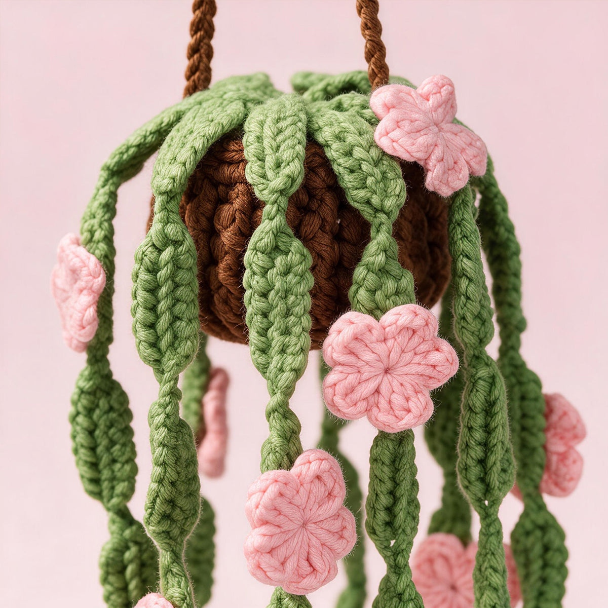 Crochet à la main suspendu Pot ornement avec des feuilles vertes trailing et des fleurs roses jamais