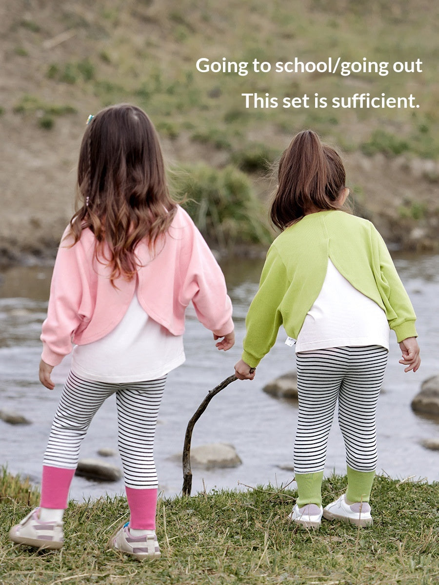Les filles mignonnes fixent le top floral et les leggings rayés