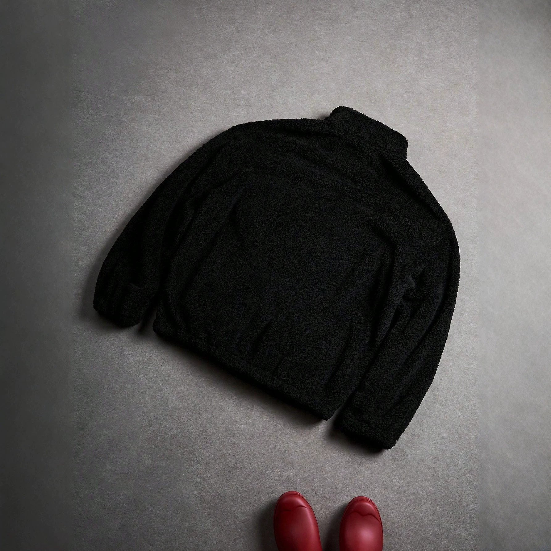 Veste de fourrure noire avec une fermeture éclair et broderie sur la poitrine gauche