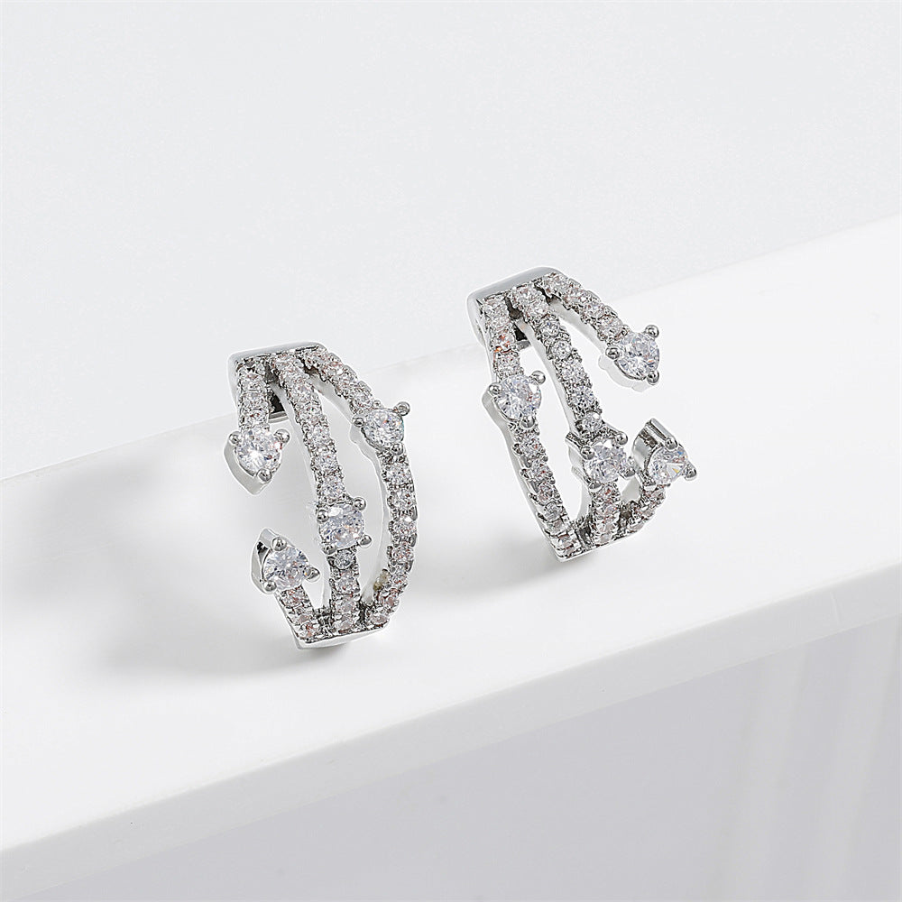 Boucles d'oreilles CZ Huggie entremêlées femmes