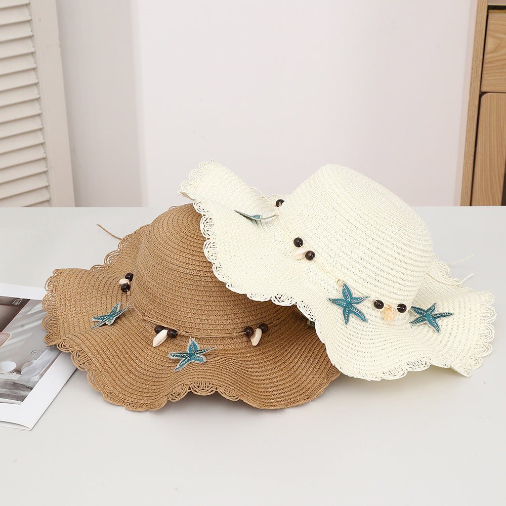 Chapeau d'étoiles et de paille de coquillage de style bohème avec un bord large et un bord de wavy parfait pour le soleil