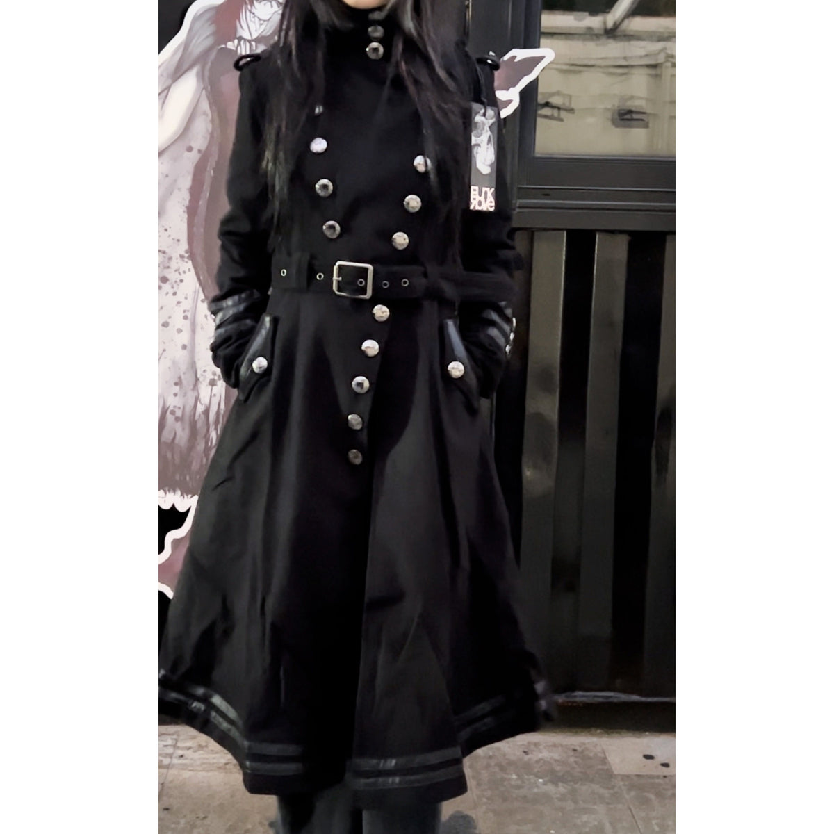 Short punk-style coat, longer at the back than at the front, with a fitted waist