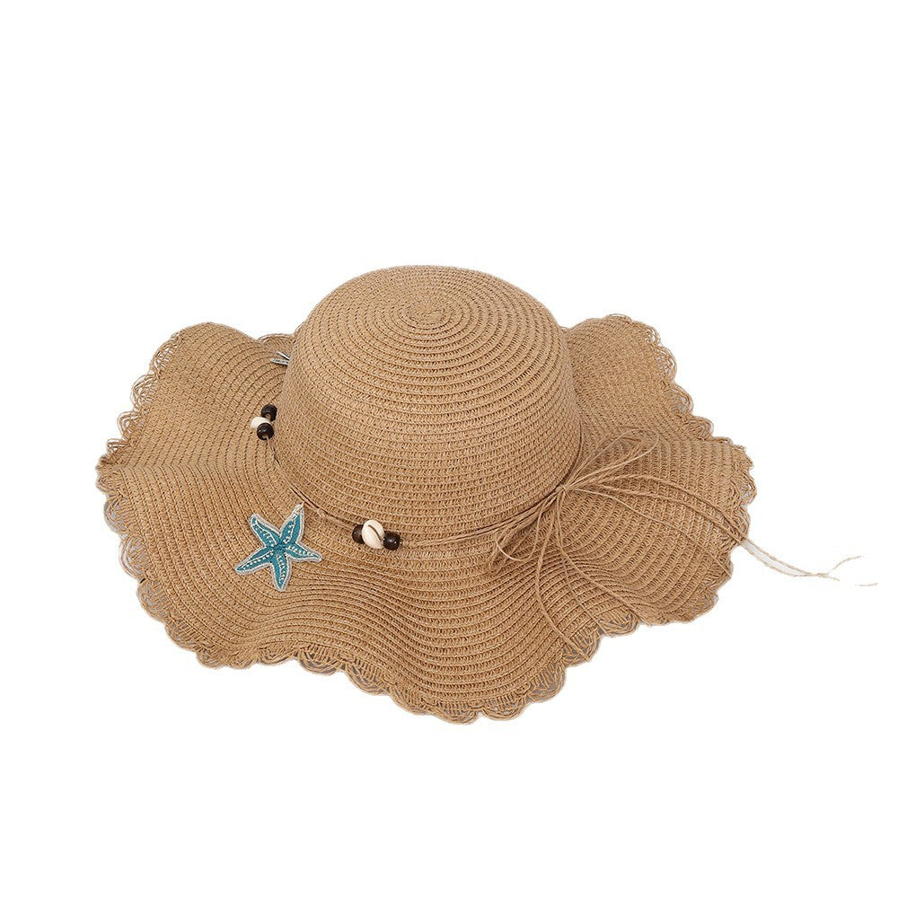 Chapeau d'étoiles et de paille de coquillage de style bohème avec un bord large et un bord de wavy parfait pour le soleil