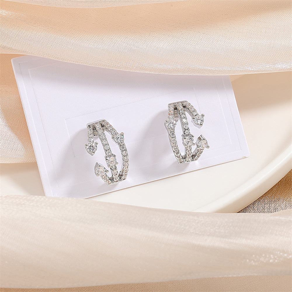 Boucles d'oreilles CZ Huggie entremêlées femmes