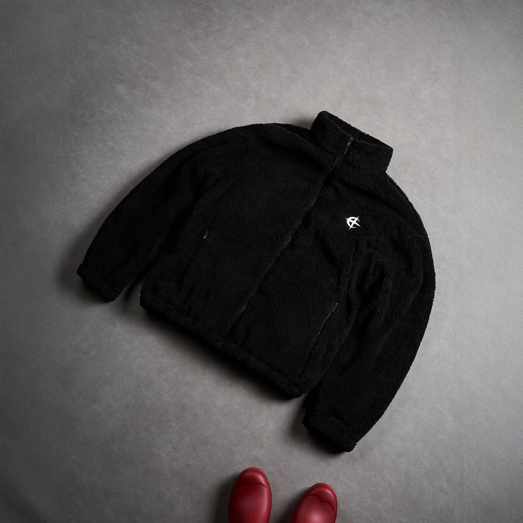 Veste de fourrure noire avec une fermeture éclair et broderie sur la poitrine gauche