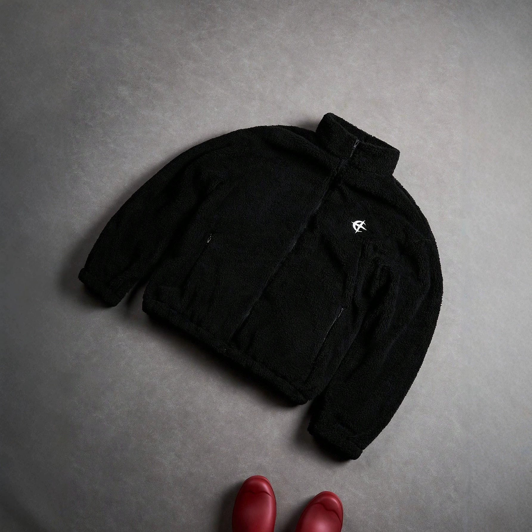 Veste de fourrure noire avec une fermeture éclair et broderie sur la poitrine gauche