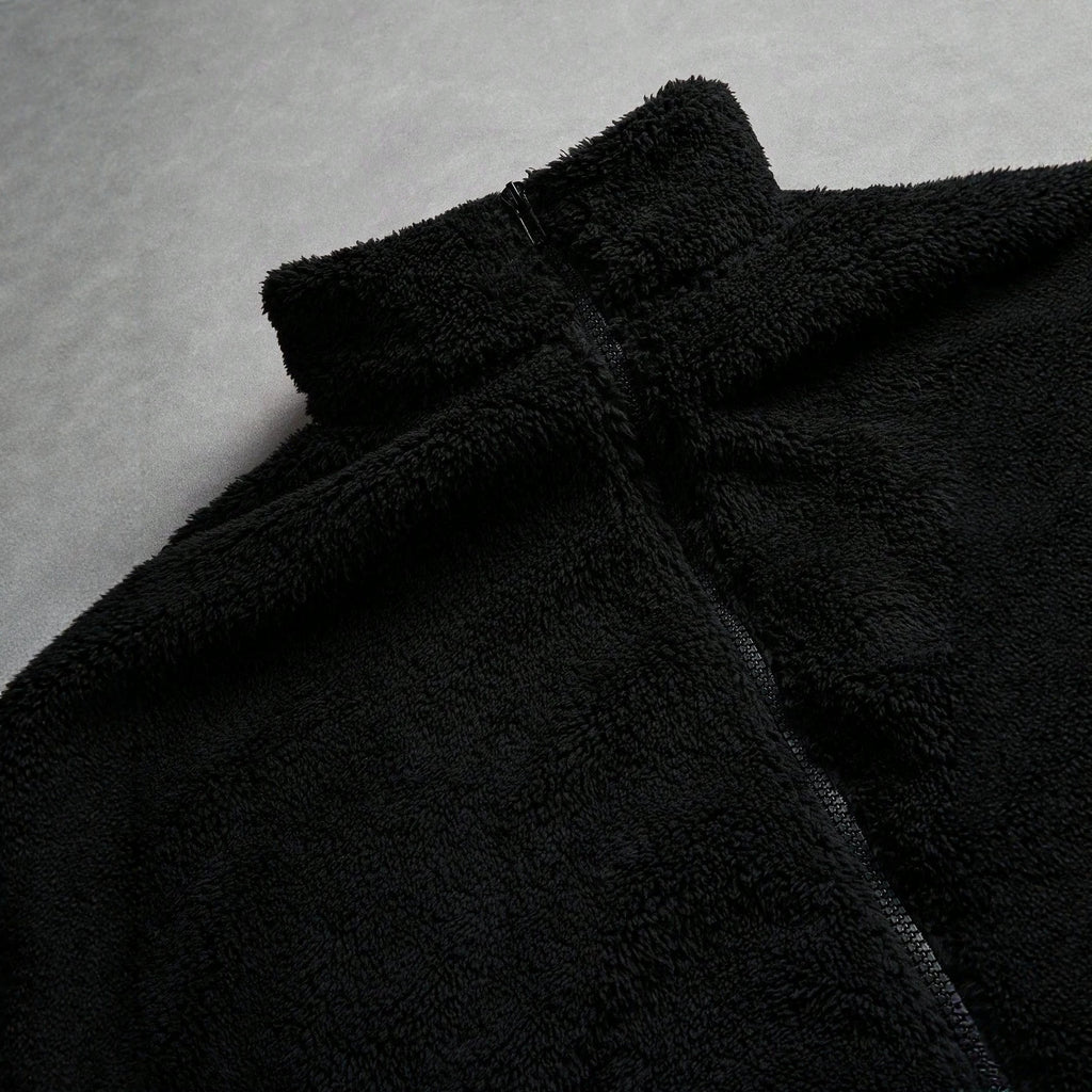 Veste de fourrure noire avec une fermeture éclair et broderie sur la poitrine gauche