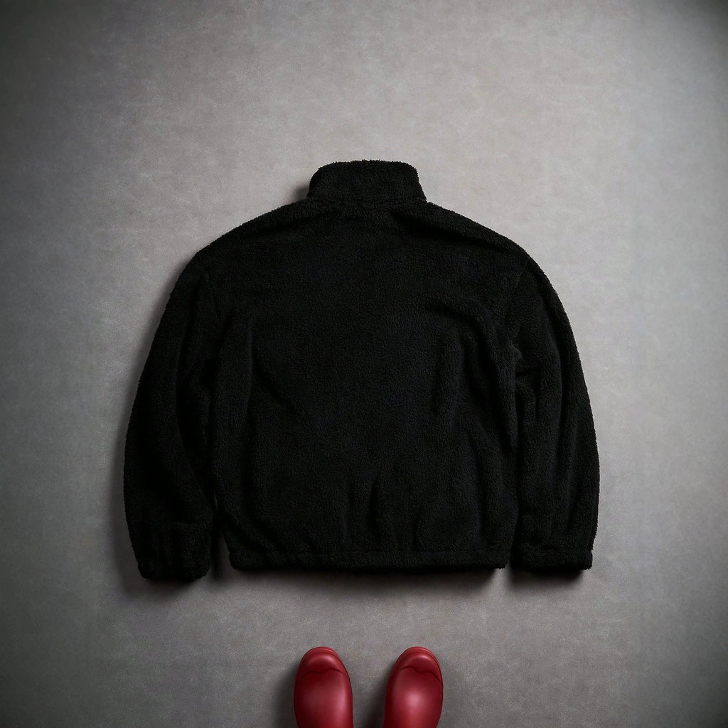 Veste de fourrure noire avec une fermeture éclair et broderie sur la poitrine gauche