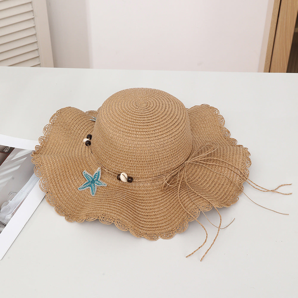 Chapeau d'étoiles et de paille de coquillage de style bohème avec un bord large et un bord de wavy parfait pour le soleil