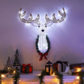 Tête de renne au mur de Noël éclairé