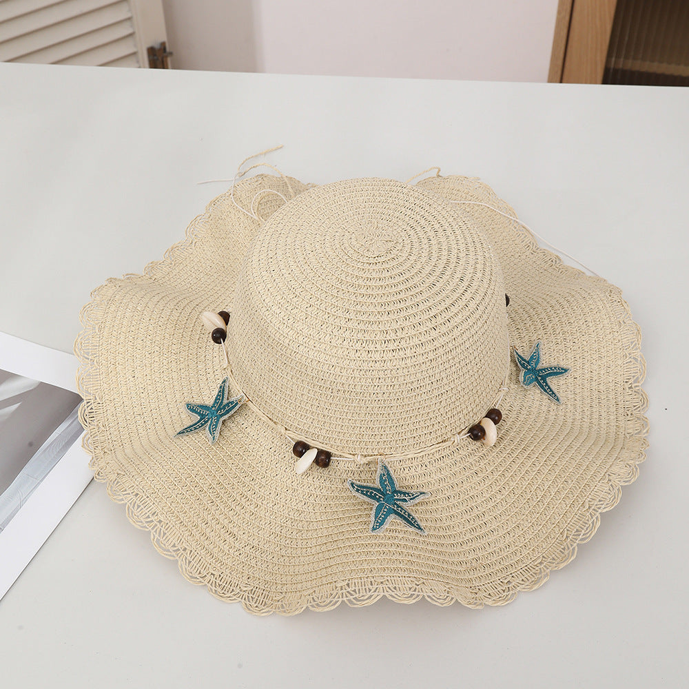 Chapeau d'étoiles et de paille de coquillage de style bohème avec un bord large et un bord de wavy parfait pour le soleil