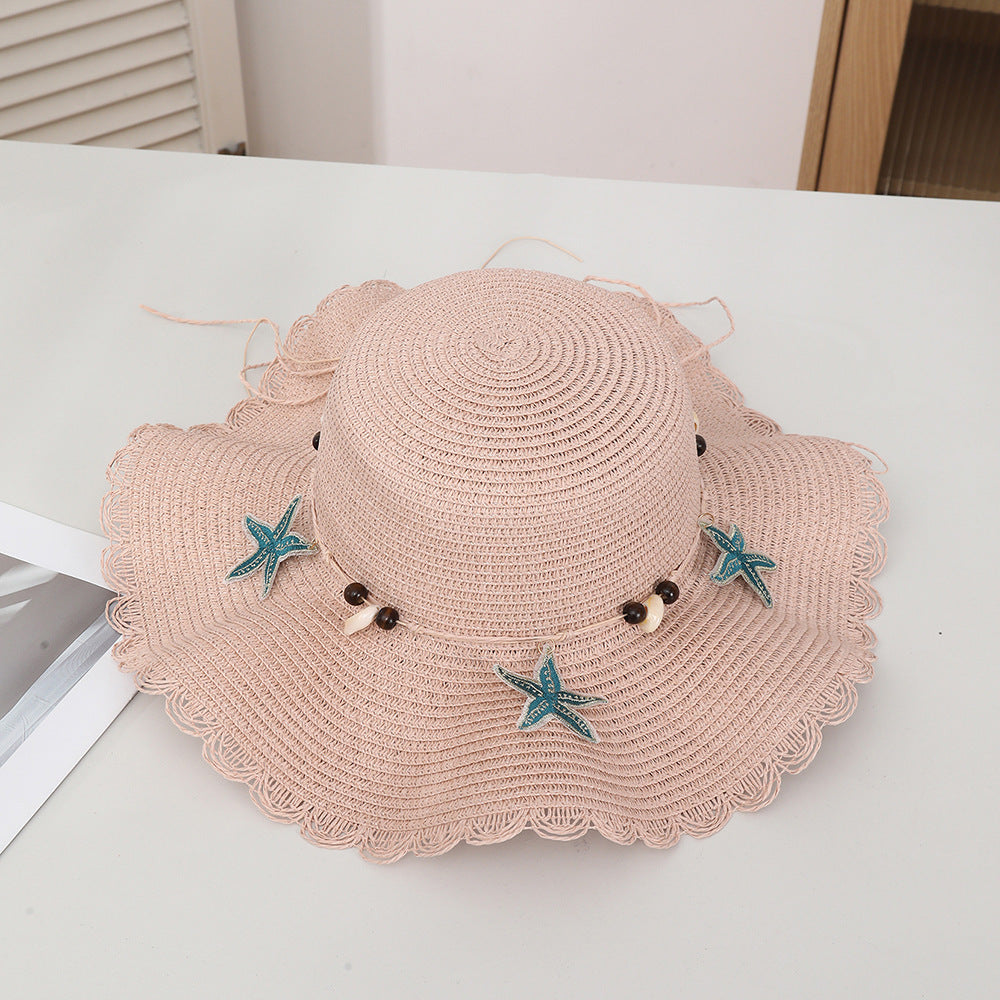 Chapeau d'étoiles et de paille de coquillage de style bohème avec un bord large et un bord de wavy parfait pour le soleil