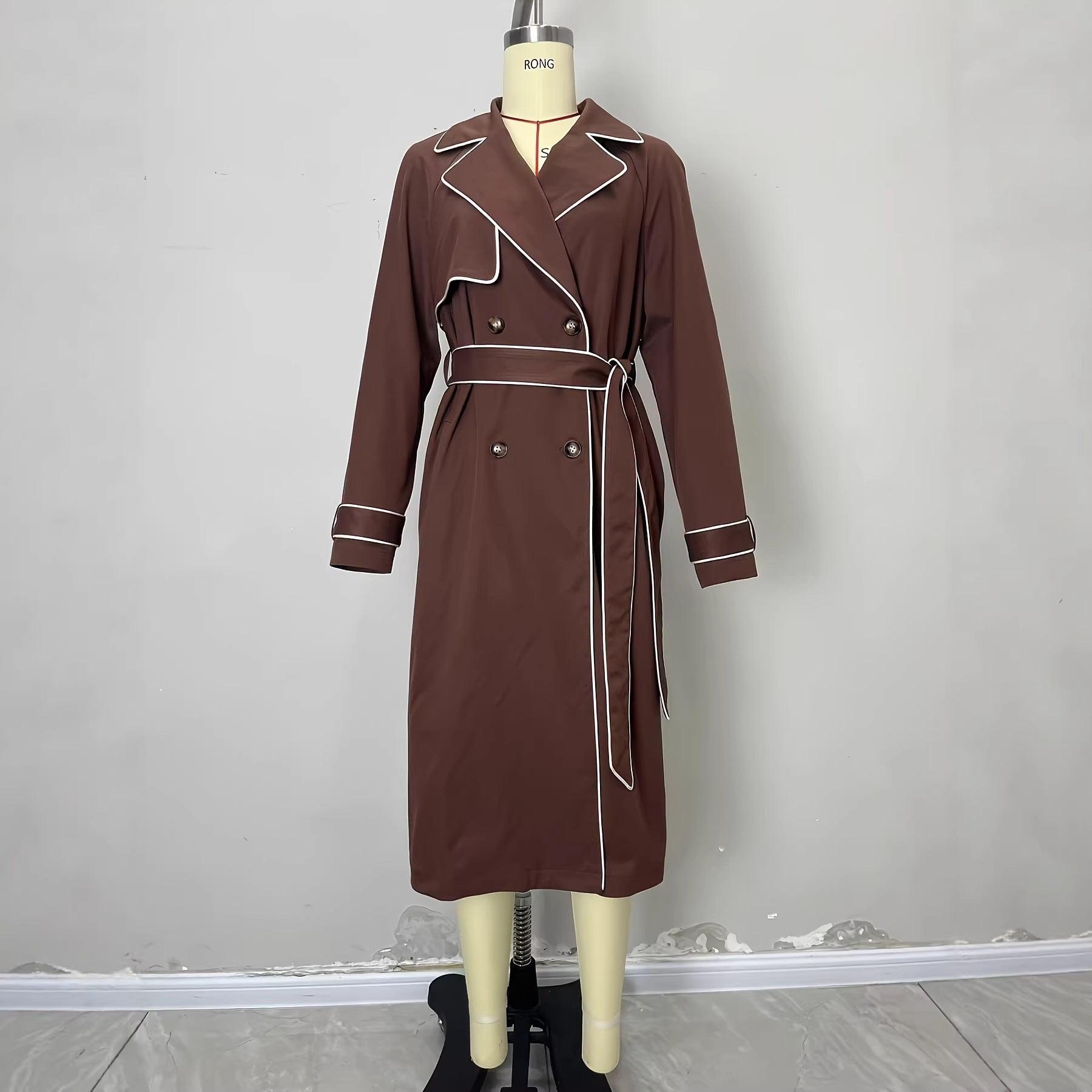 Manteau de tranchée avec pointage exposé une ligne de taille définie et une ceinture de cravate