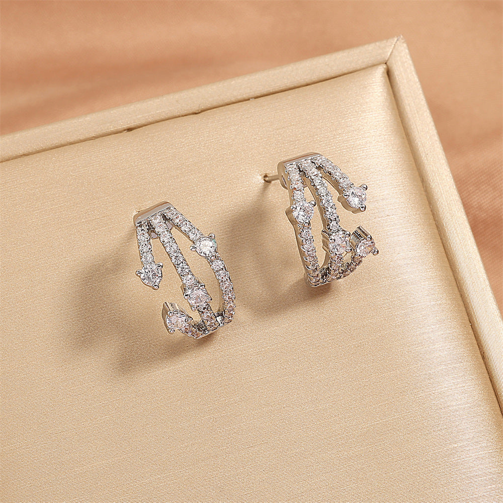 Boucles d'oreilles CZ Huggie entremêlées femmes