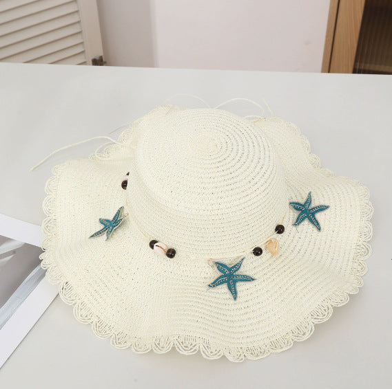 Chapeau d'étoiles et de paille de coquillage de style bohème avec un bord large et un bord de wavy parfait pour le soleil